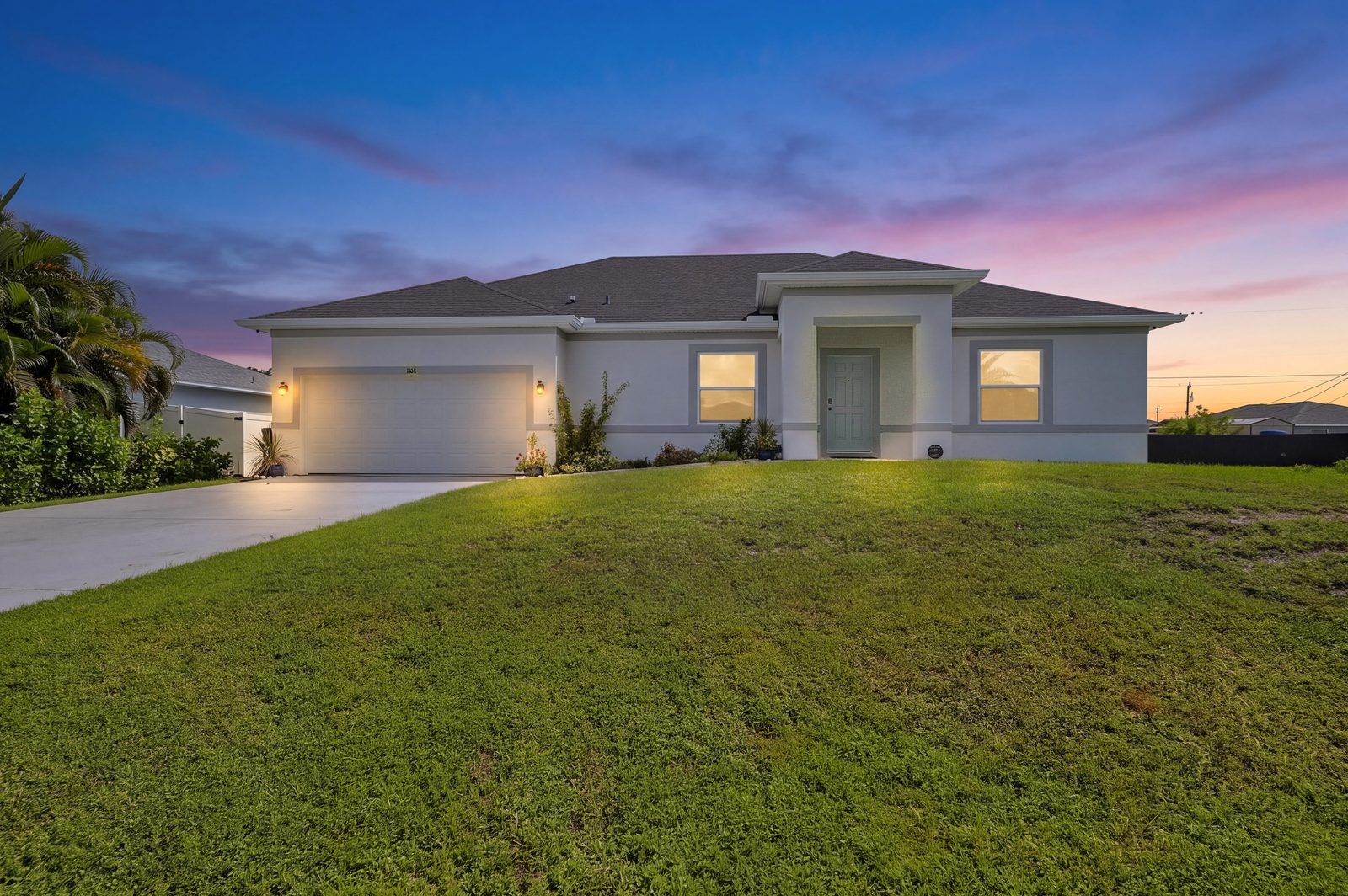1108 NW 14th Terrace, Cape Coral FL at twilight - front elevation of a 2024-built concrete block home
